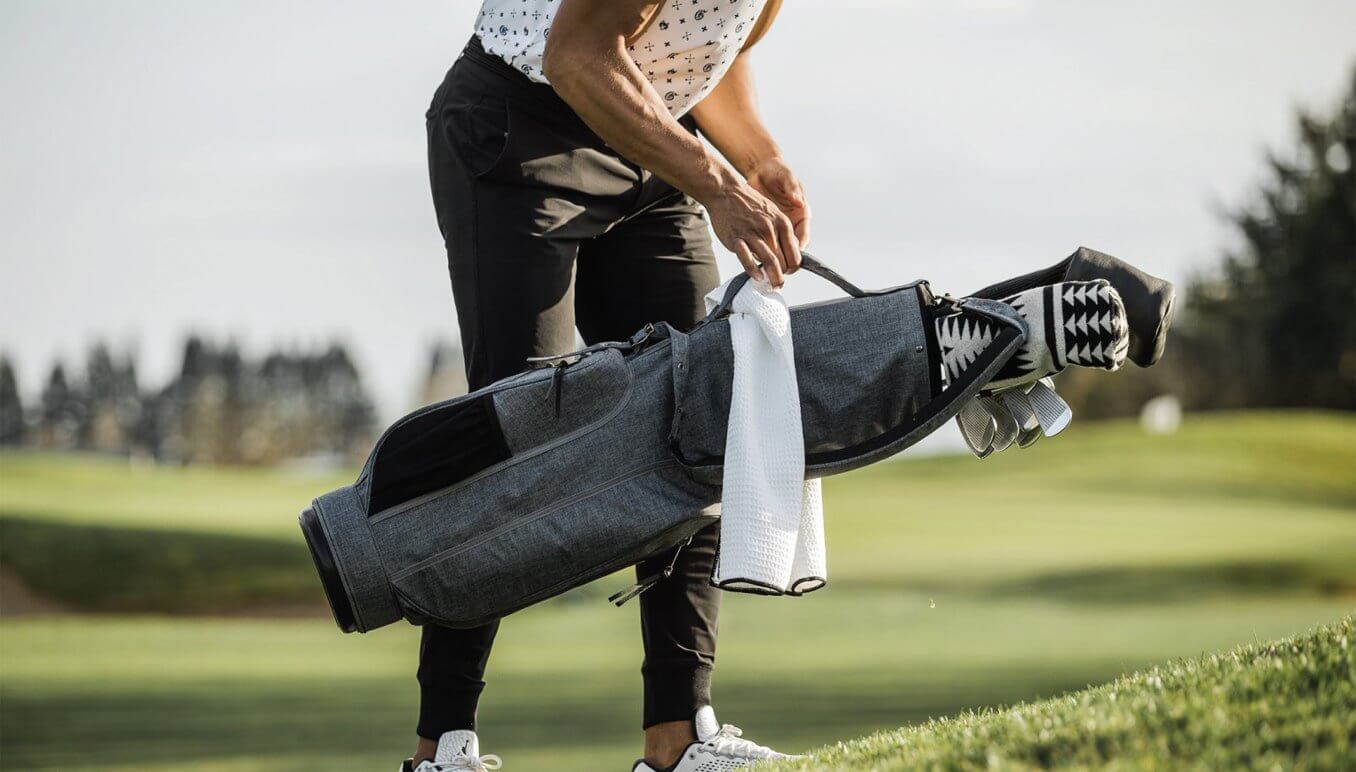 Hombre con una bolsa de lápiz de golf en las manos mientras juega en el campo