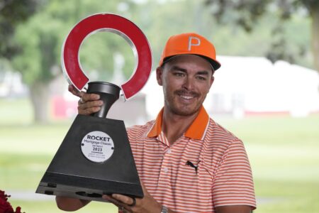 Rickie Fowler holds the winner's trophy after winning on the first play-off hole on the 18th green during the final round of the Rocket Mortgage Classic golf tournament at Detroit Country Club, Sunday, July 2, 2023, in Detroit. (AP Photo/Carlos Osorio)